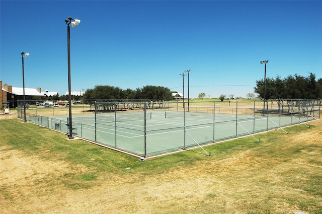 view of tennis court with a lawn