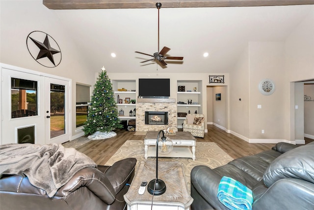 living room with a fireplace, built in shelves, ceiling fan, and hardwood / wood-style floors