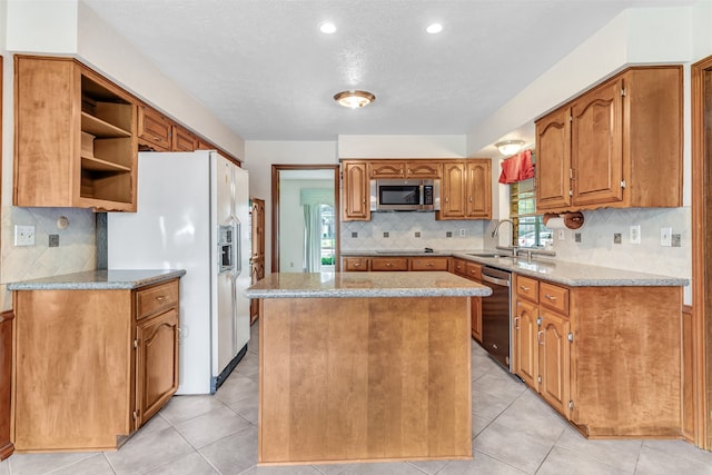 kitchen featuring tasteful backsplash, stainless steel appliances, light tile patterned floors, sink, and a center island