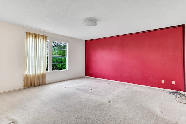 spare room with a textured ceiling and light carpet