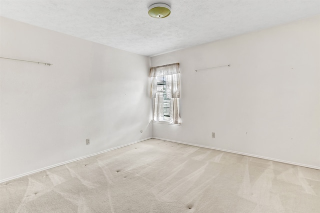 carpeted spare room with a textured ceiling