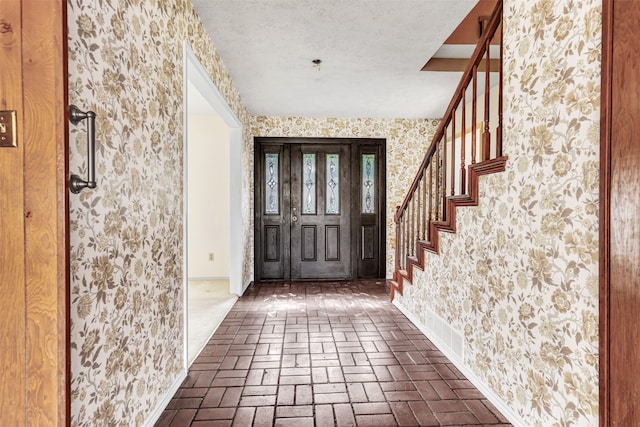 foyer entrance featuring a textured ceiling