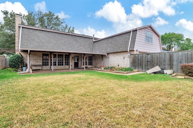 back of house with a lawn and a patio