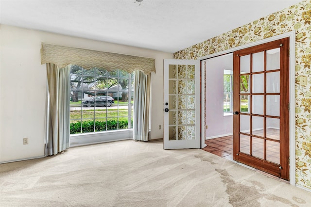 interior space featuring a textured ceiling, french doors, and light carpet