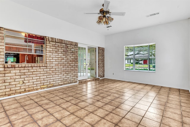 empty room featuring brick wall and ceiling fan