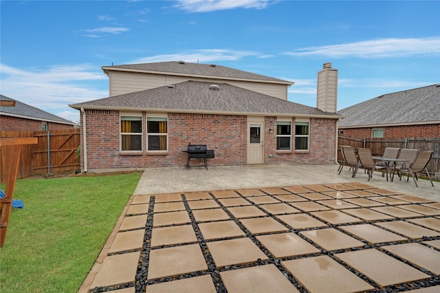 back of house with a yard and a patio