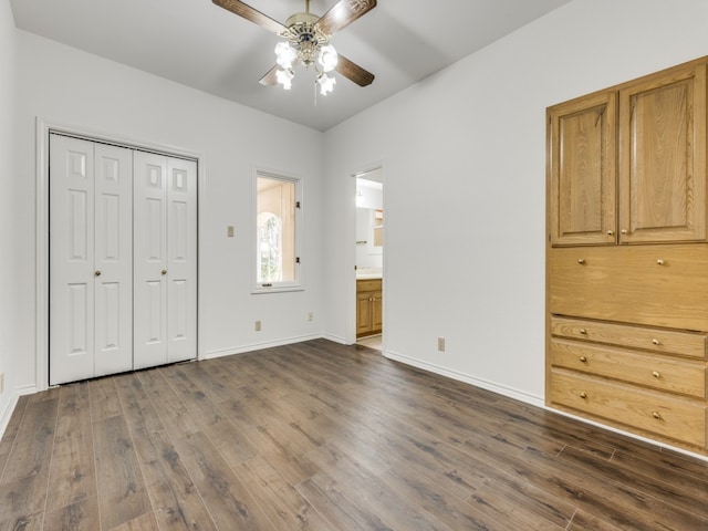 unfurnished bedroom with ceiling fan, dark hardwood / wood-style flooring, connected bathroom, and a closet