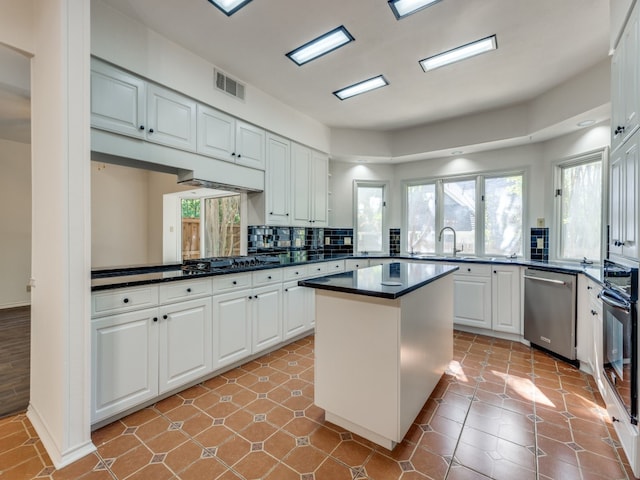 kitchen featuring a center island, sink, tasteful backsplash, white cabinets, and black appliances