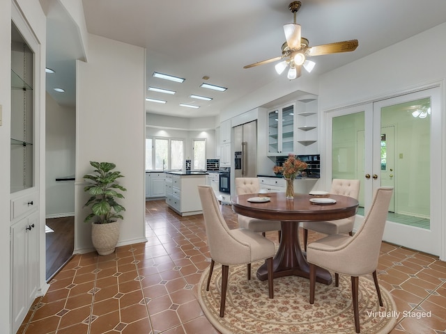 dining room with dark tile patterned floors and ceiling fan