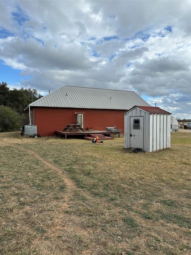 back of property featuring a shed and a yard