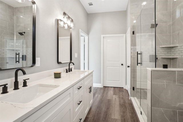 bathroom featuring wood-type flooring, vanity, and a shower with shower door