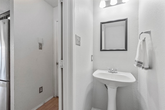 bathroom featuring wood-type flooring and a textured ceiling