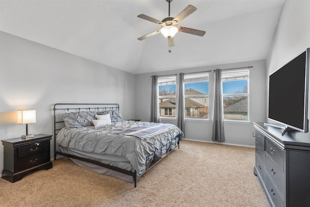 bedroom featuring lofted ceiling, a textured ceiling, light carpet, and ceiling fan