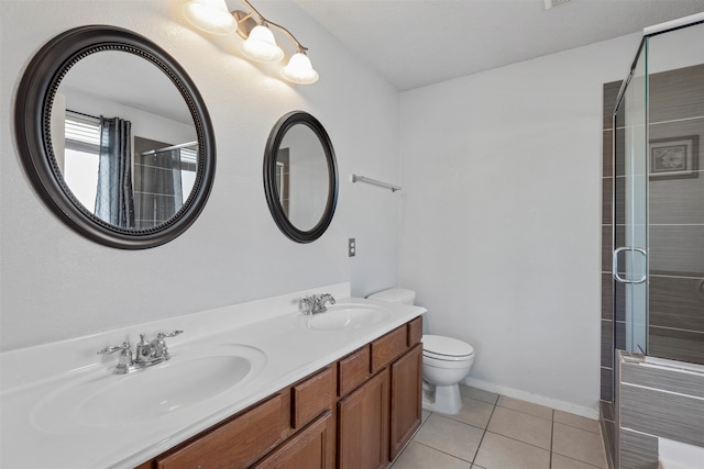 bathroom featuring vanity, a shower with door, tile patterned floors, and toilet