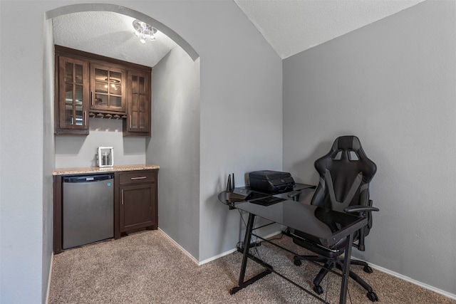 carpeted office space with lofted ceiling and a textured ceiling