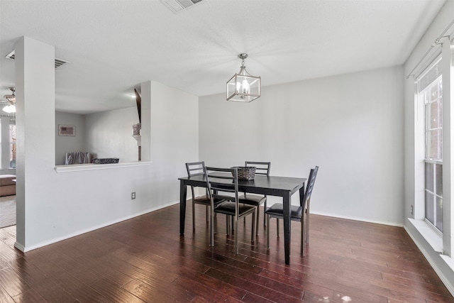 dining space featuring ceiling fan with notable chandelier and dark hardwood / wood-style floors