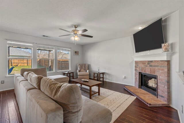 living room featuring a brick fireplace, ceiling fan, and dark hardwood / wood-style flooring