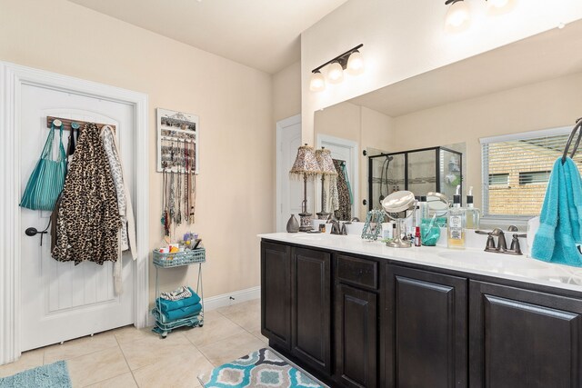 bathroom with walk in shower, vanity, and tile patterned flooring