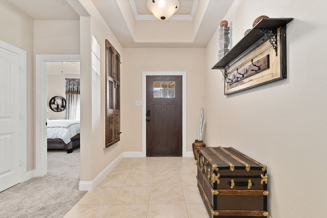 foyer entrance featuring a tray ceiling and light carpet