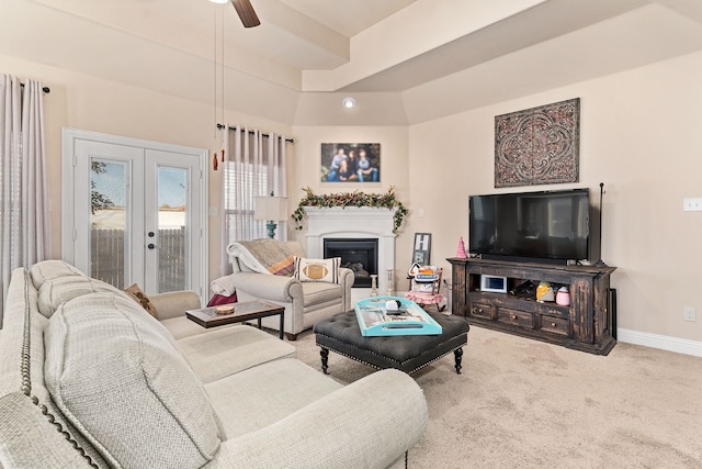 carpeted living room with ceiling fan, french doors, and a tray ceiling