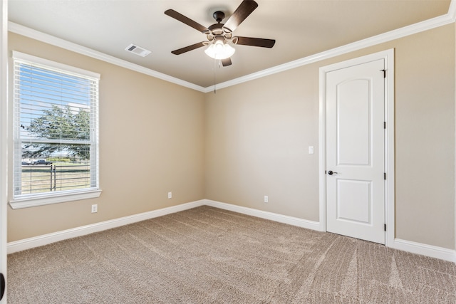 carpeted empty room with ceiling fan and ornamental molding