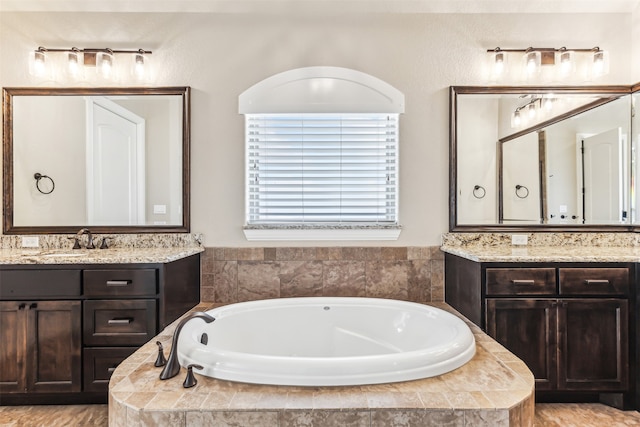 bathroom featuring tiled bath and vanity