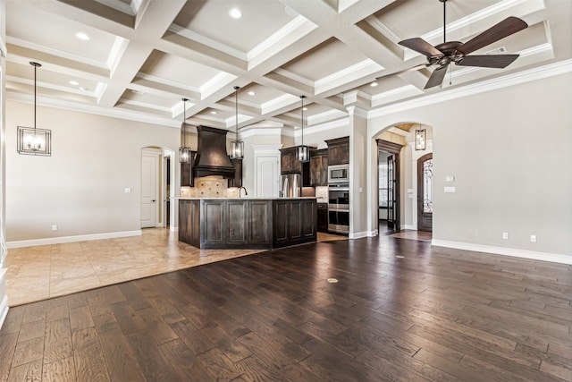 kitchen with dark wood-type flooring, premium range hood, decorative light fixtures, and stainless steel appliances