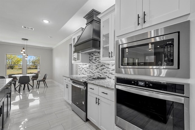 1055 Encino Ct, Wills Point, TX 75169 - kitchen with appliances with stainless steel finishes, premium range hood, light stone countertops, ornamental molding, and decorative backsplash