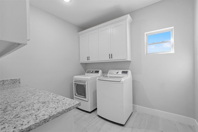 laundry area with cabinets and washing machine and clothes dryer