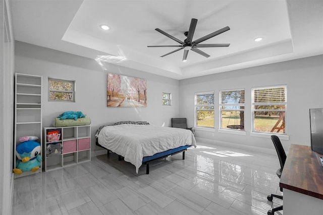 bedroom featuring ceiling fan and a raised ceiling