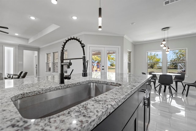 kitchen with sink, ornamental molding, light stone countertops, pendant lighting, and french doors