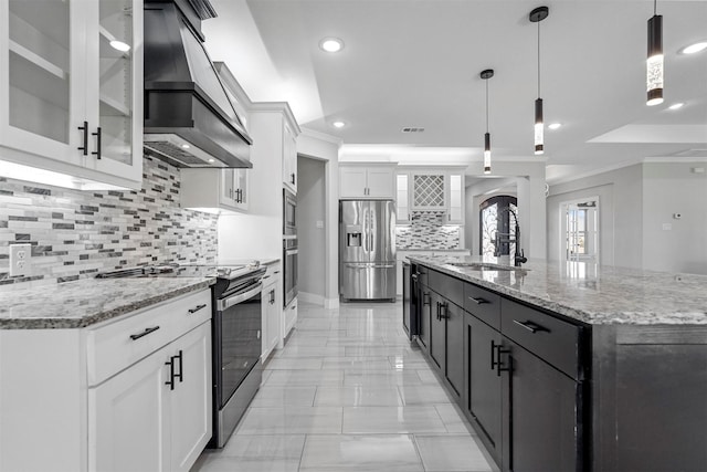 1055 Encino Ct, Wills Point, TX 75169 - kitchen featuring custom range hood, appliances with stainless steel finishes, tasteful backsplash, a sink, and white cabinetry