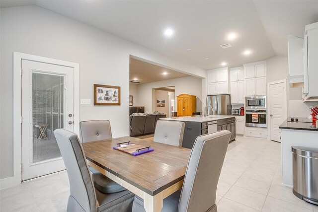 kitchen with sink, a kitchen island with sink, appliances with stainless steel finishes, and tasteful backsplash