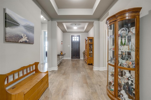 entrance foyer with light wood-type flooring and a tray ceiling