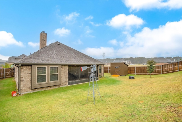 rear view of property featuring a yard and a shed