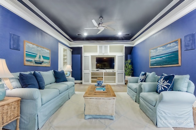 living room with crown molding, built in features, a raised ceiling, and ceiling fan