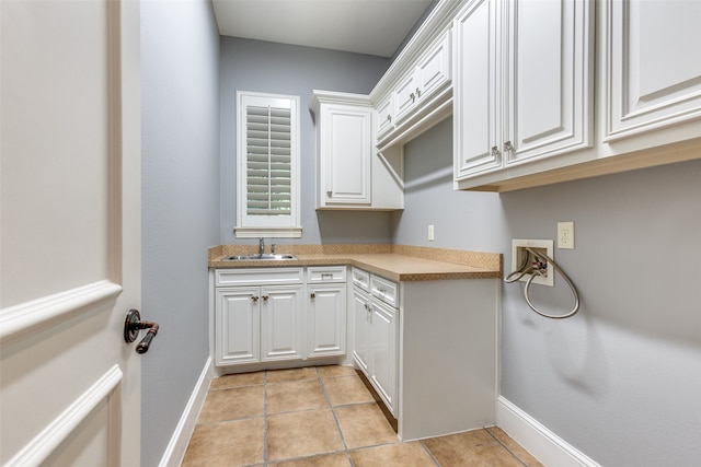 washroom featuring cabinets, hookup for a washing machine, sink, and light tile patterned floors