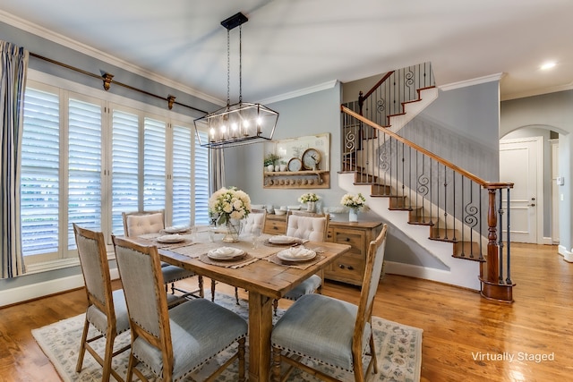 dining space with ornamental molding and light hardwood / wood-style floors