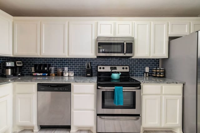 kitchen with stainless steel appliances, light stone counters, and tasteful backsplash