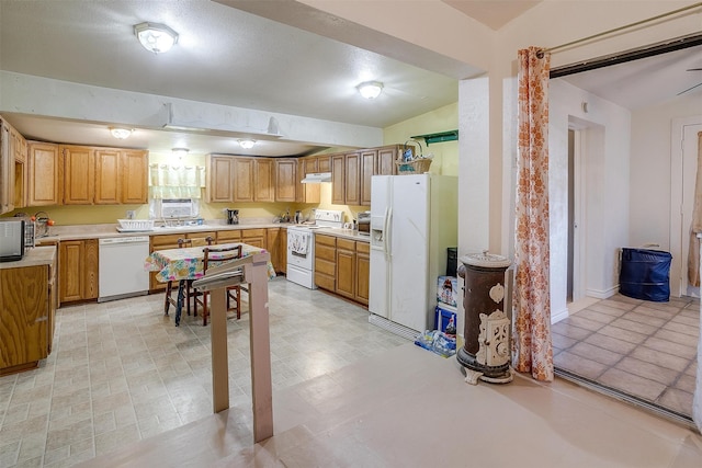 kitchen with sink, white appliances, and vaulted ceiling