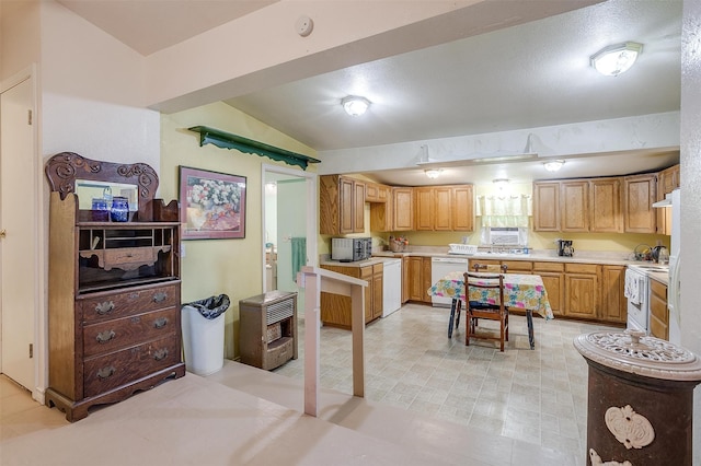 kitchen featuring sink, white appliances, and vaulted ceiling