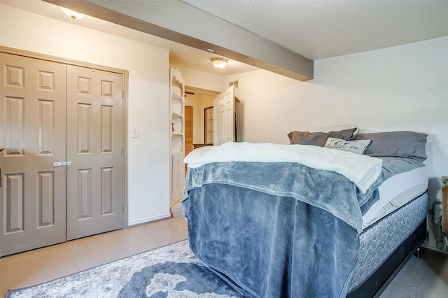 bedroom with a closet, concrete floors, and a textured ceiling