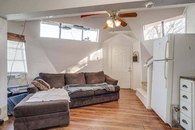 living room with ceiling fan, cooling unit, light wood-type flooring, and lofted ceiling with beams