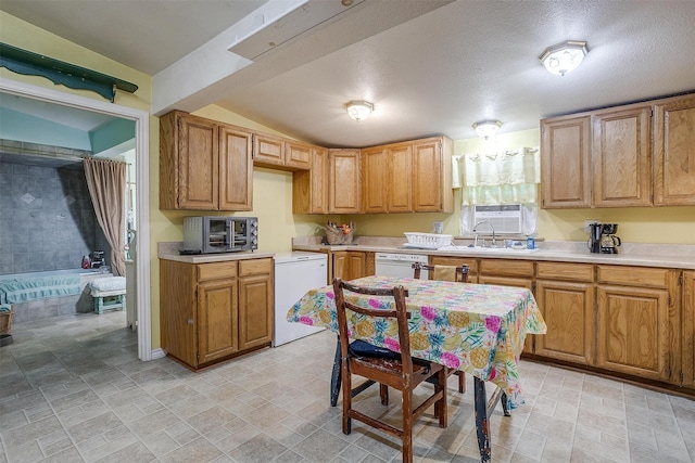 kitchen featuring white appliances, a textured ceiling, sink, and lofted ceiling