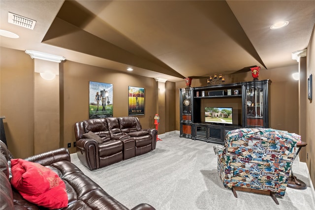 home theater room with carpet, lofted ceiling, and ornate columns