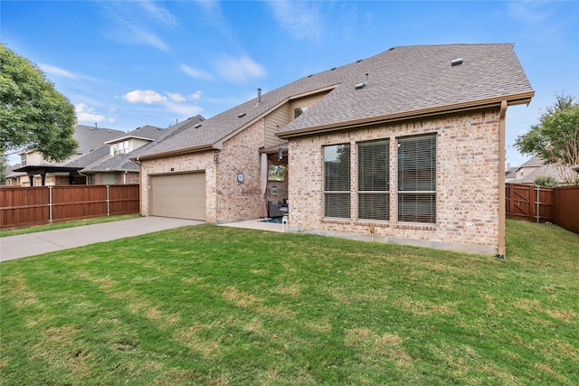 rear view of house featuring a lawn and a garage