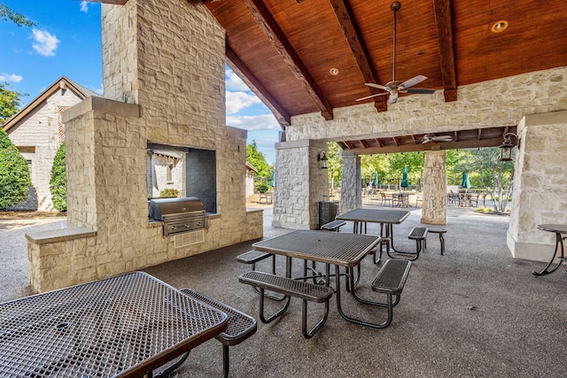 view of patio / terrace with ceiling fan, a grill, and an outdoor stone fireplace