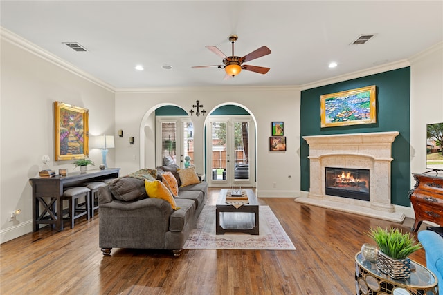 living room featuring ornamental molding, wood-type flooring, and ceiling fan