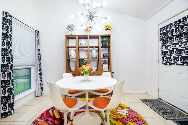 dining room with a chandelier, lofted ceiling, and light tile patterned flooring