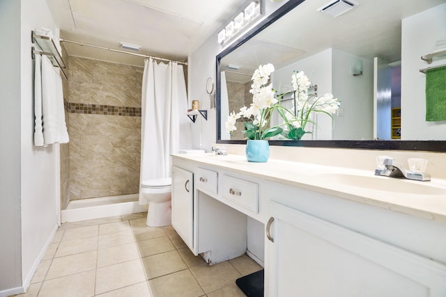 bathroom with toilet, a shower with curtain, vanity, and tile patterned floors